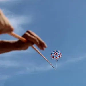 a person flying through the air while holding a blue umbrella