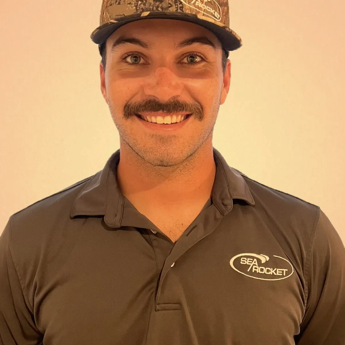 a man wearing a hat and smiling at the camera