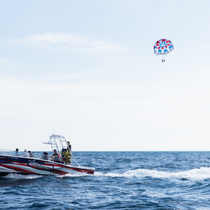 a man flying a kite in a boat on a body of water