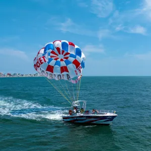 a person flying a kite in a boat on a body of water