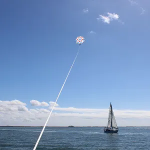 a man flying a kite in a boat on a body of water