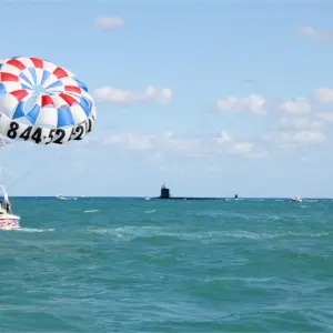 a group of people flying kites in a body of water