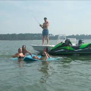 a man riding on the back of a boat in the water